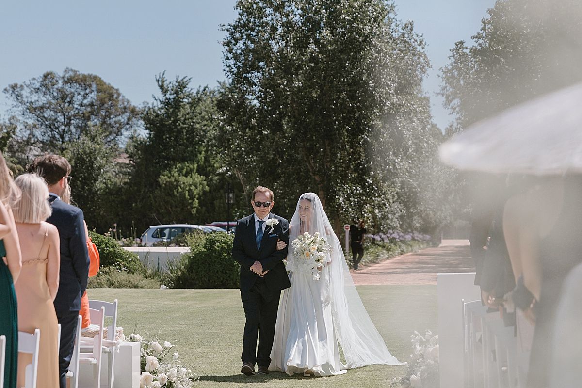 Bride and groom sharing a joyful moment at Weltevreden Estate, with elegant floral arrangements and Cape Dutch architecture.