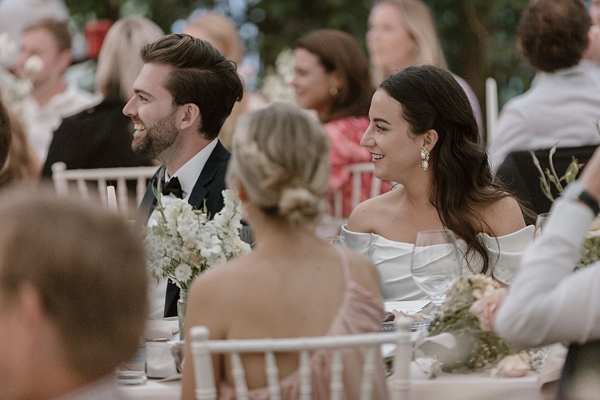 Bride and groom sharing a joyful moment at Weltevreden Estate, with elegant floral arrangements and Cape Dutch architecture.