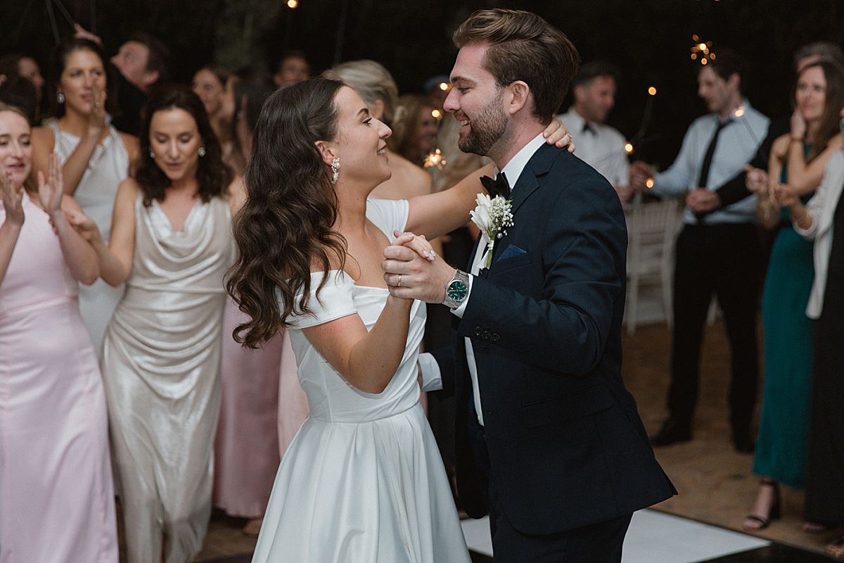 Bride and groom sharing a joyful moment at Weltevreden Estate, with elegant floral arrangements and Cape Dutch architecture.