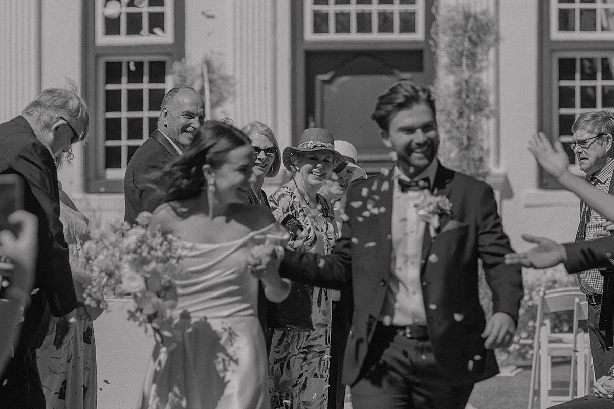 Bride and groom sharing a joyful moment at Weltevreden Estate, with elegant floral arrangements and Cape Dutch architecture.