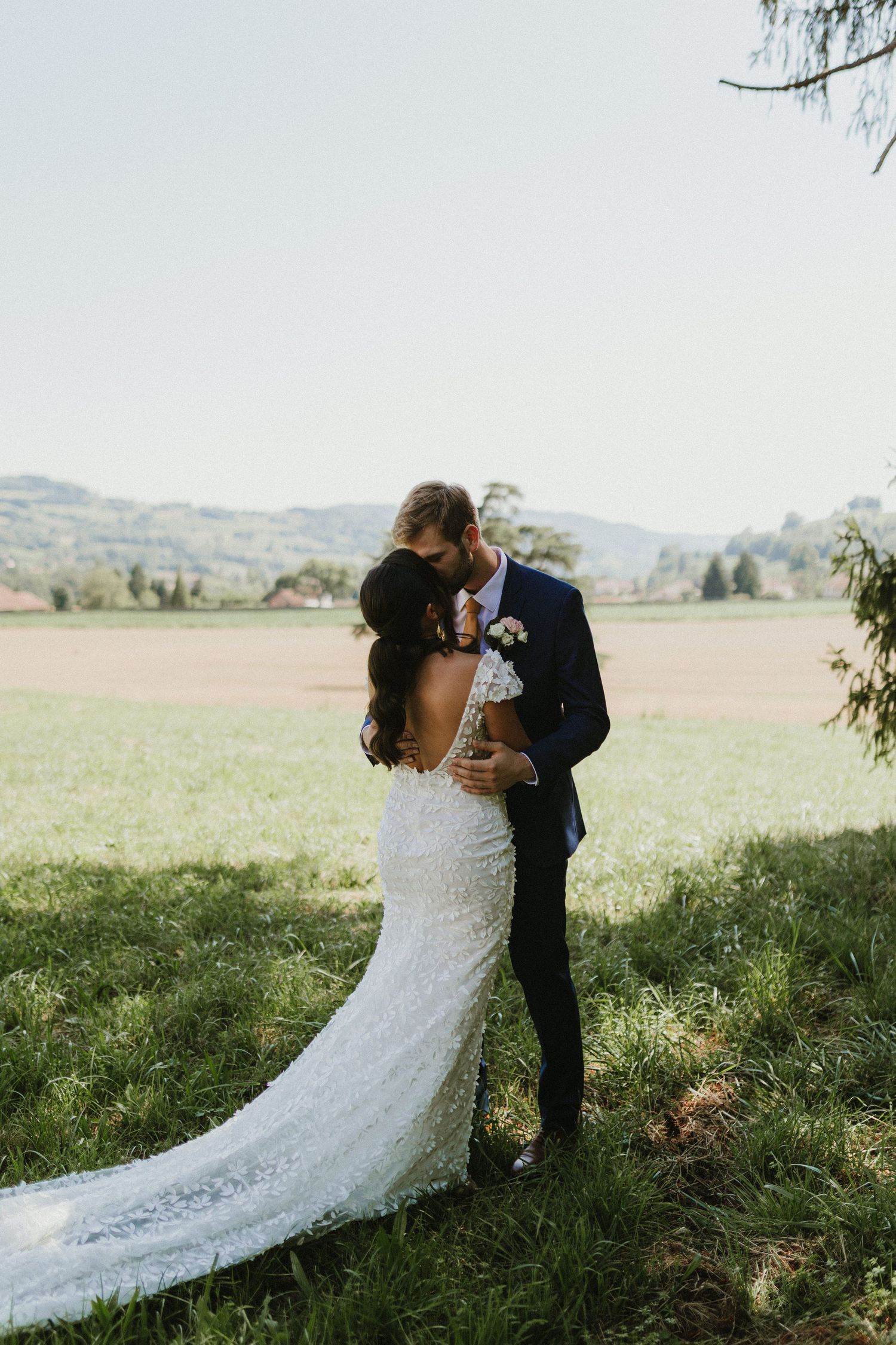 A couple shares an intimate moment in a beautiful countryside setting during their wedding.