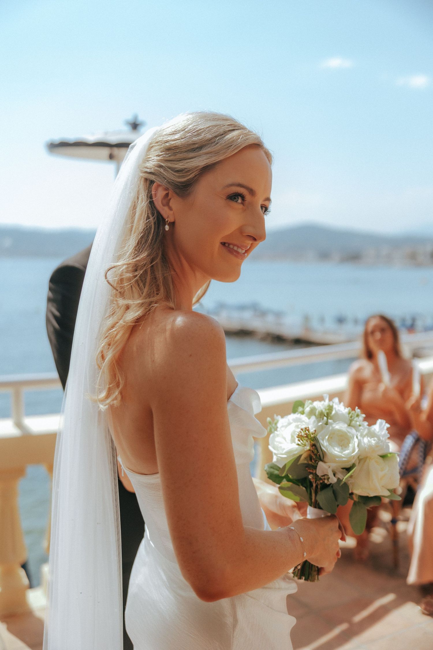 Elegant seaside wedding with ocean views and coastal mountains in background.