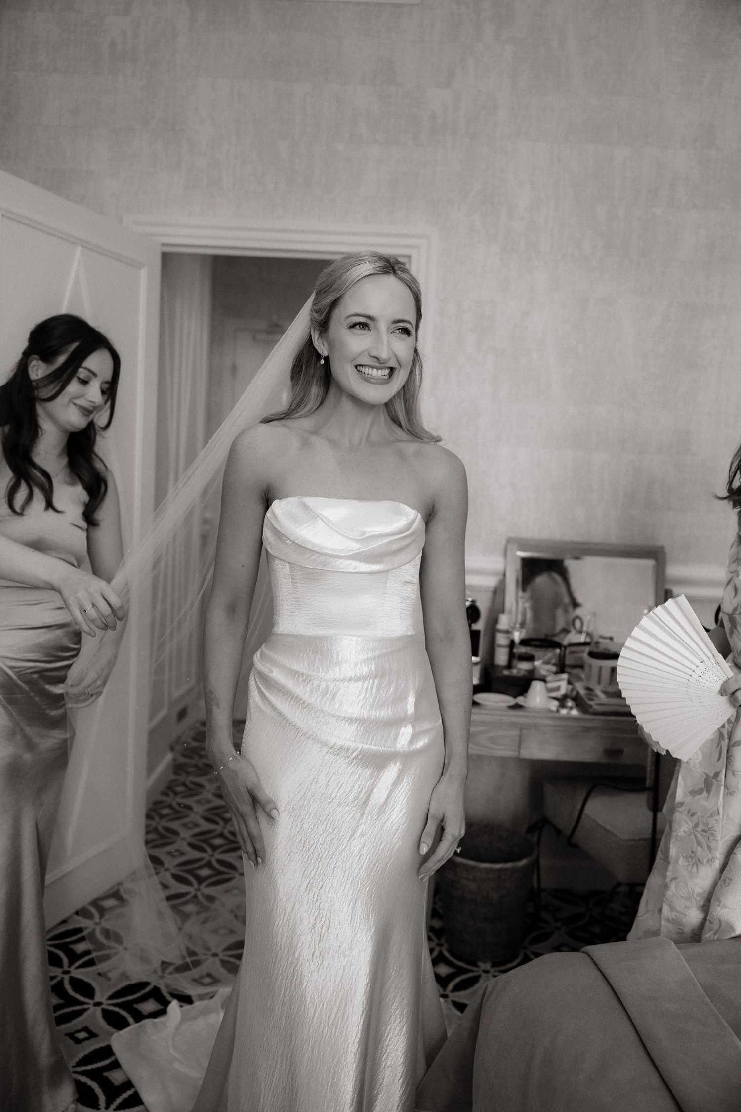 Black and white photos show bridesmaids helping the bride get ready before the wedding ceremony.