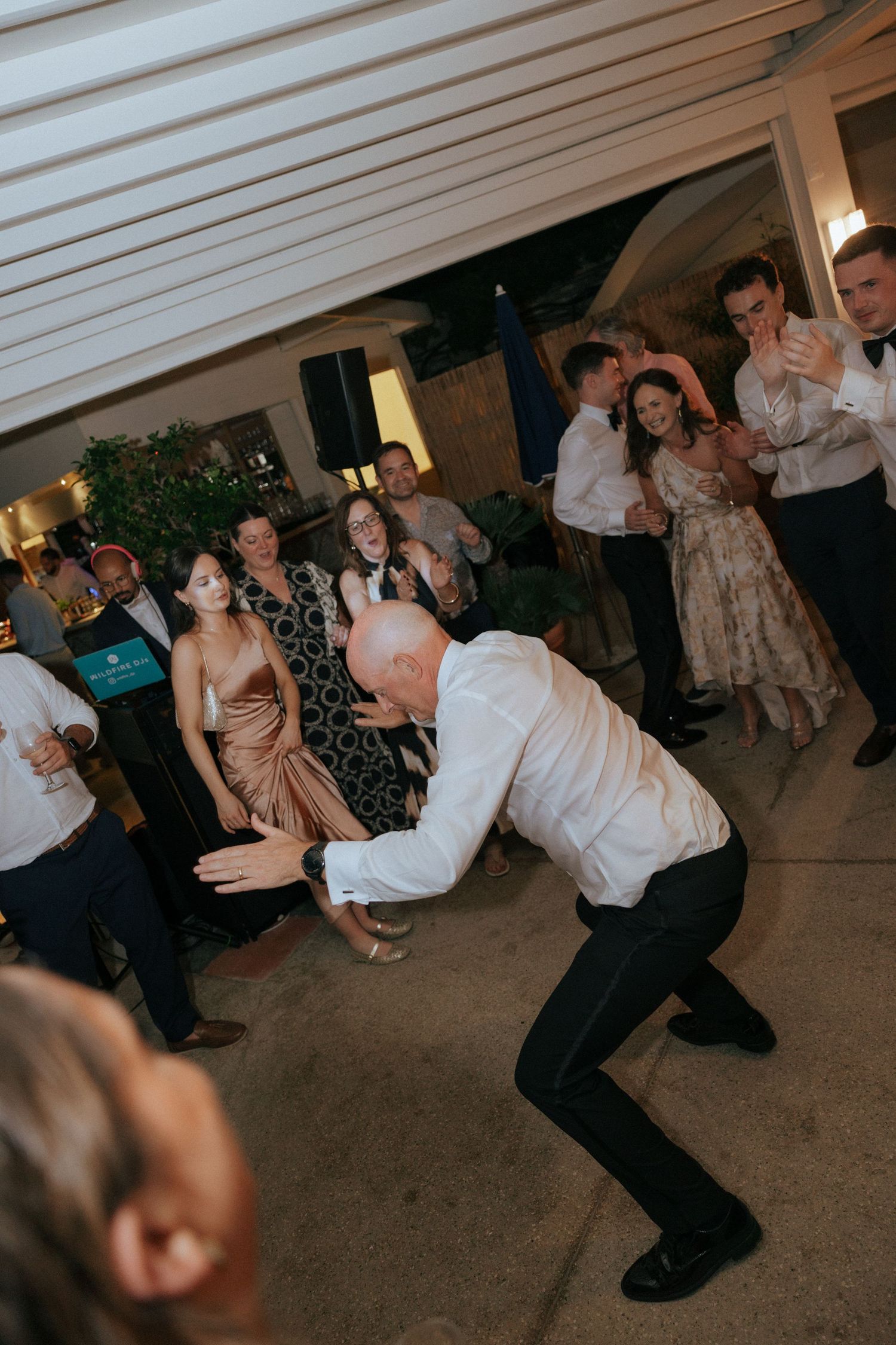 Partygoers show off their dance moves on a dark floor during an indoor celebration event.