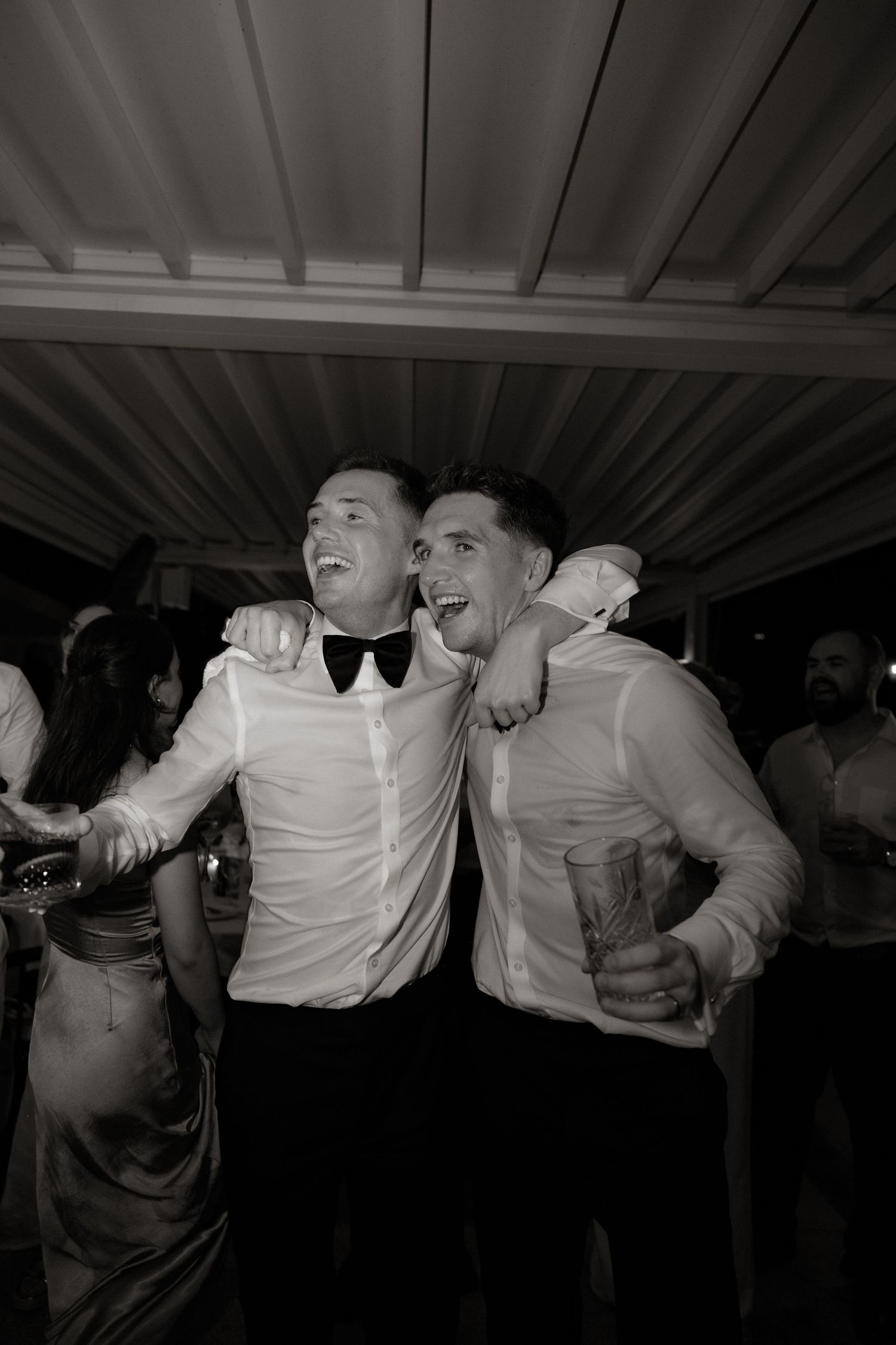 Dynamic dance sequence capturing celebratory movements at a formal event in black and white.
