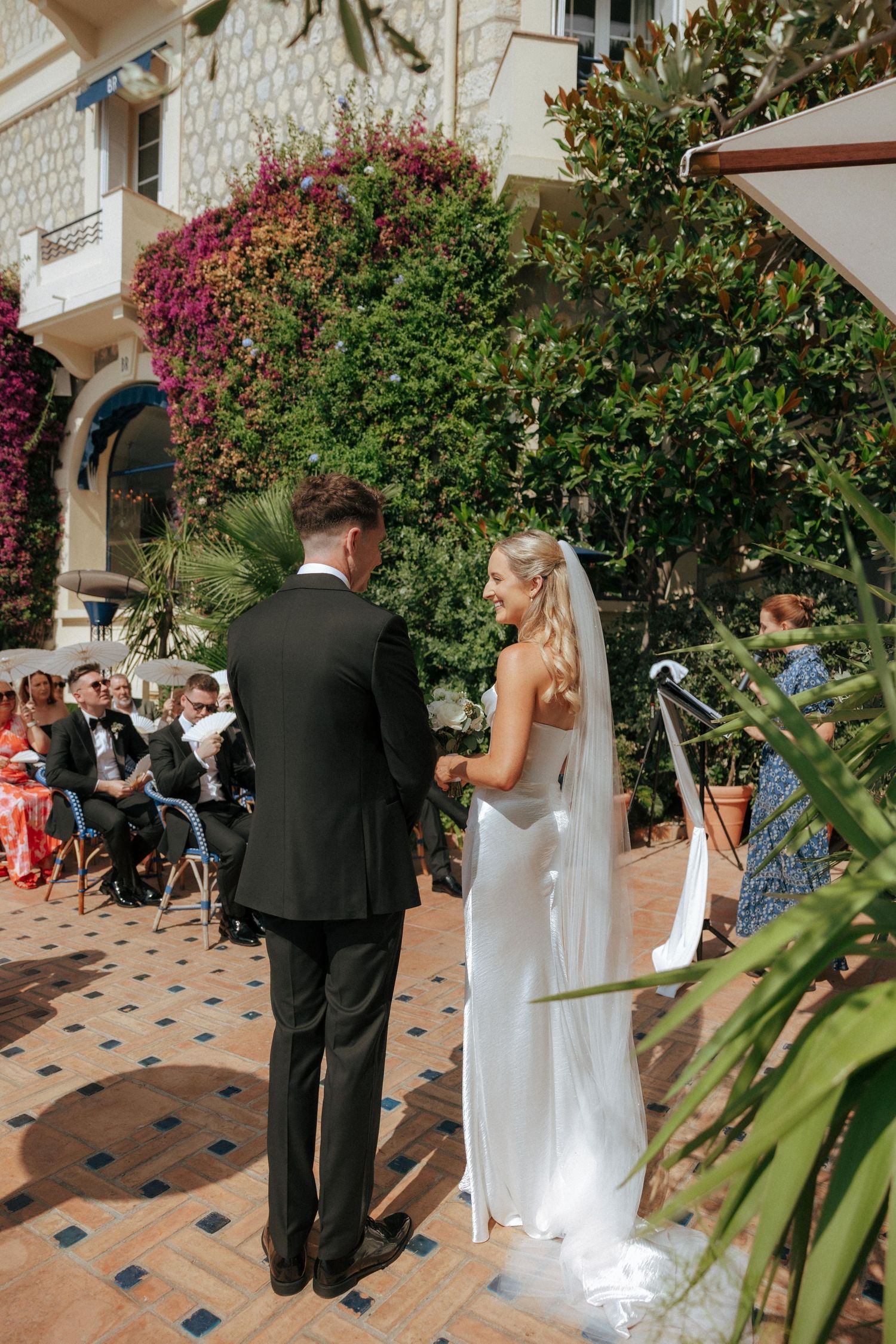 Garden wedding ceremony with flowering bougainvillea and terracotta tiled patio.