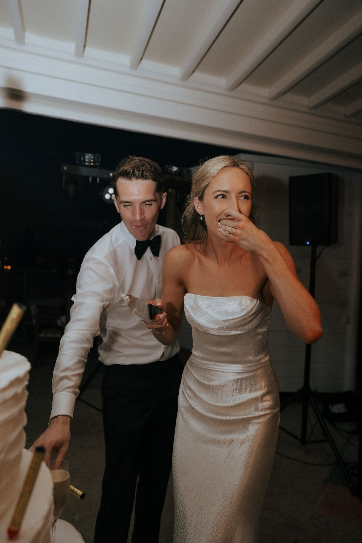 Wedding guests dancing together in formal attire at an indoor reception.