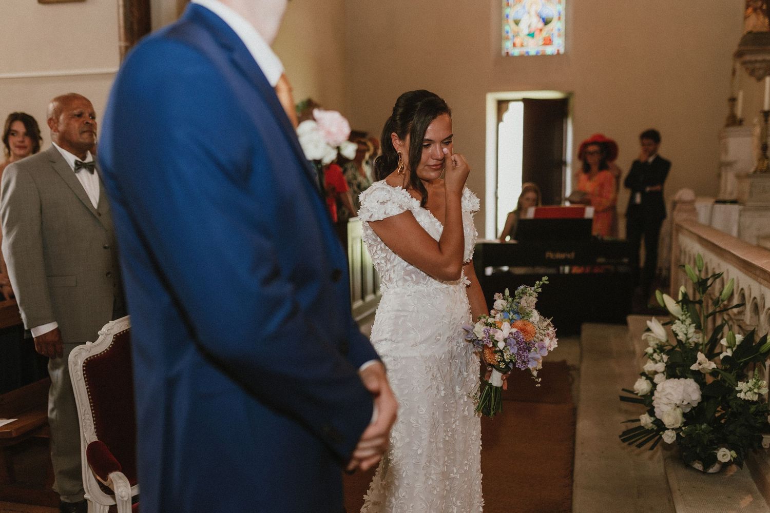 Intimate ceremony moment in a chapel with floral decorations.