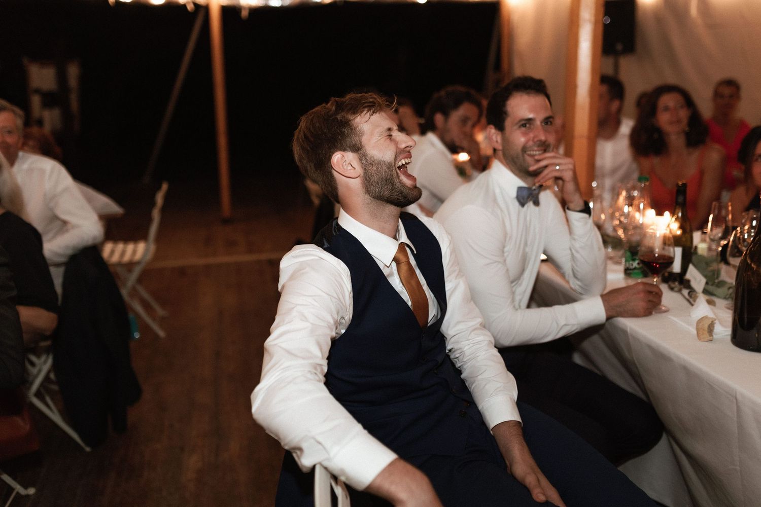 Wedding reception guests enjoying festivities under string lights.