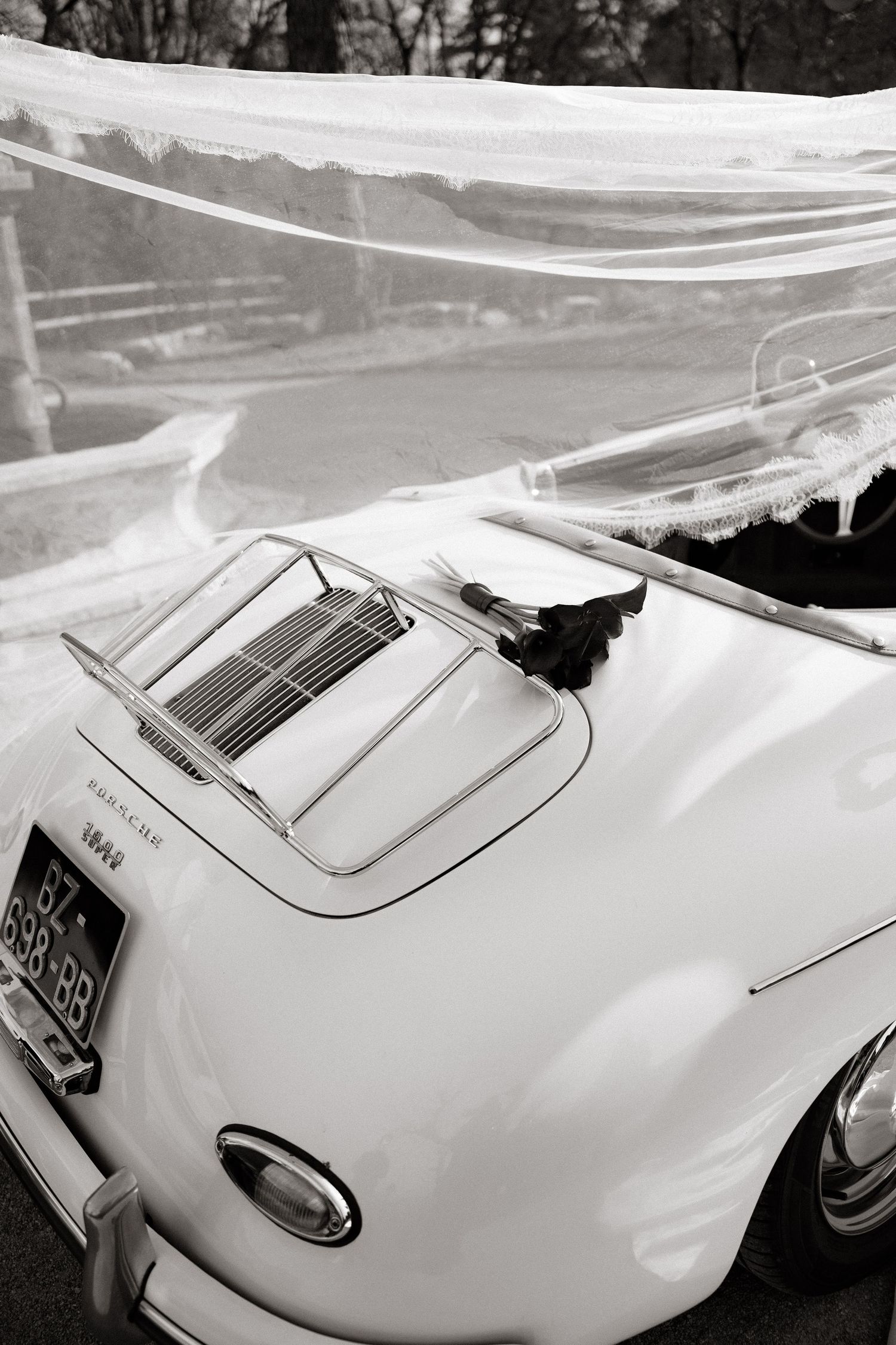 Classic white vintage Porsche convertible with shiny chrome engine vents photographed in black and white.