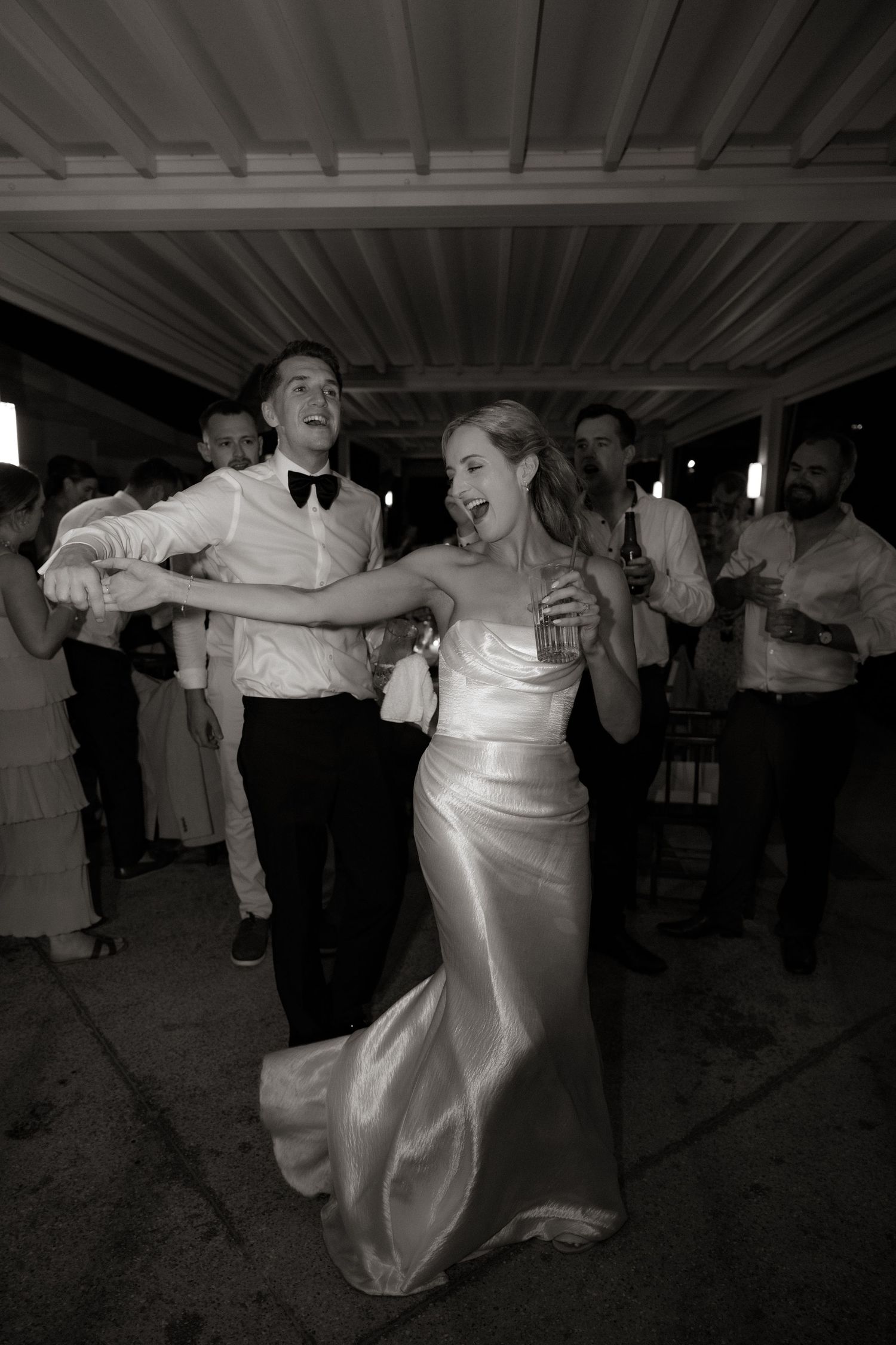 Sequential shots of dancers in white formalwear spinning and moving energetically on a dance floor.
