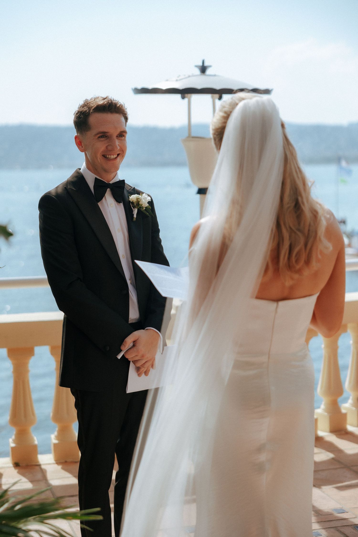 Romantic wedding moment on a seaside terrace with ocean views.