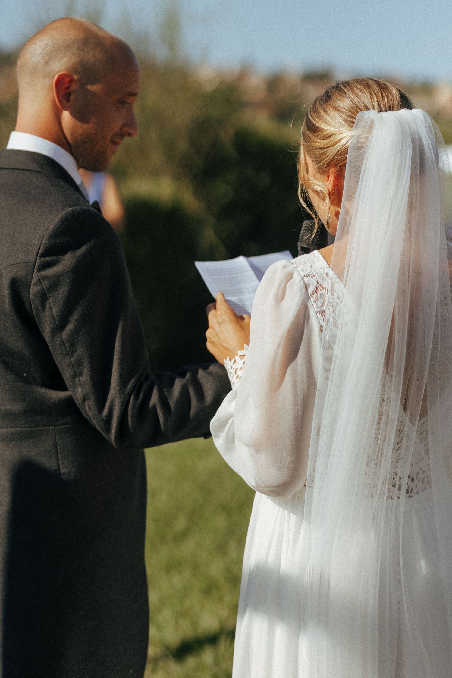A couple exchanges vows during an intimate outdoor wedding ceremony.