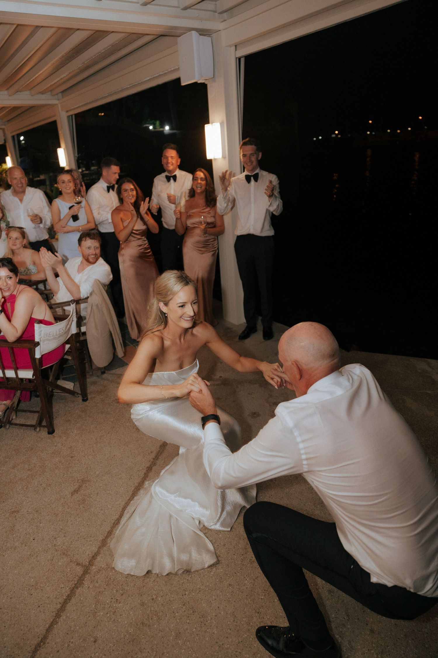 A sequence of photos shows a dynamic father-daughter wedding dance with playful moves on a covered patio at night.