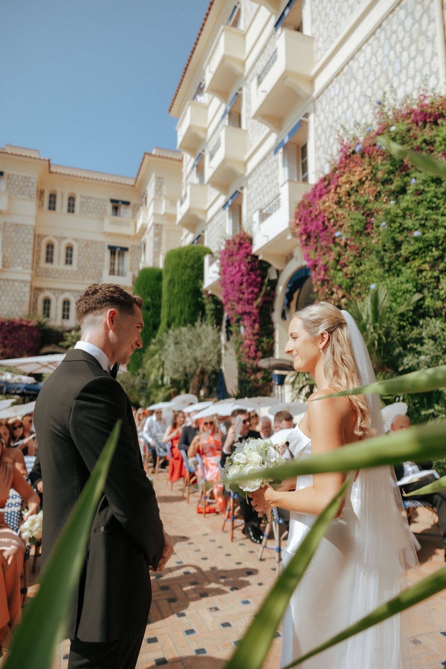 Elegant wedding ceremony on a Mediterranean terrace decorated with pink bougainvillea flowers.