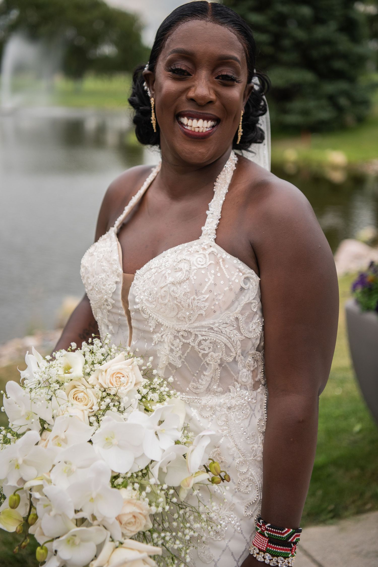 Wedding portrait with stunning white orchid bouquet and lace dress details.