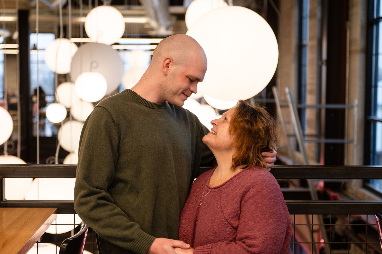 Contemporary indoor engagement session with moody lighting and casual attire.