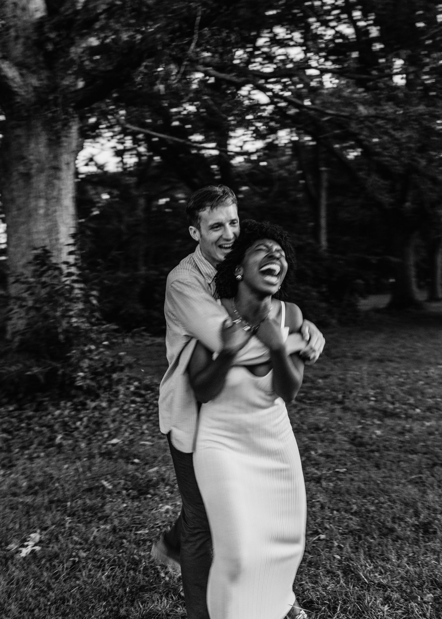 A joyful embrace captured in black and white photography outdoors.