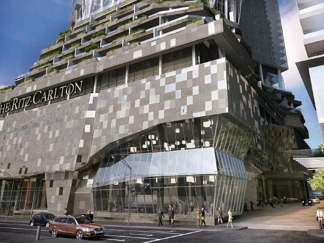 Modern glass and metal architectural facade of the Ritz Carlton building with geometric patterns and pedestrians on sidewalk.