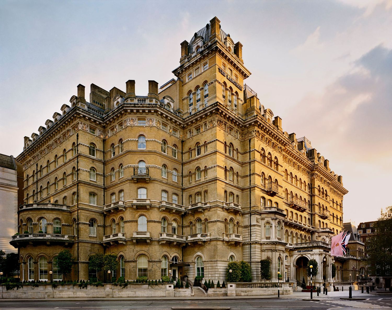 Historic Victorian-era hotel building with ornate stone facade and decorative architecture at sunset in downtown London.