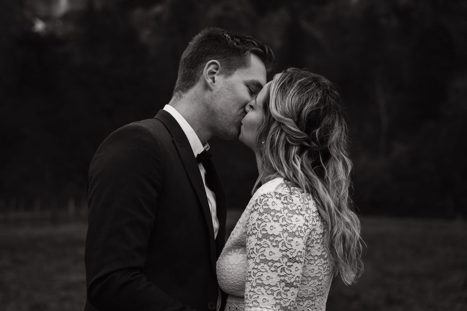 An intimate black and white portrait capturing a romantic moment between newlyweds.