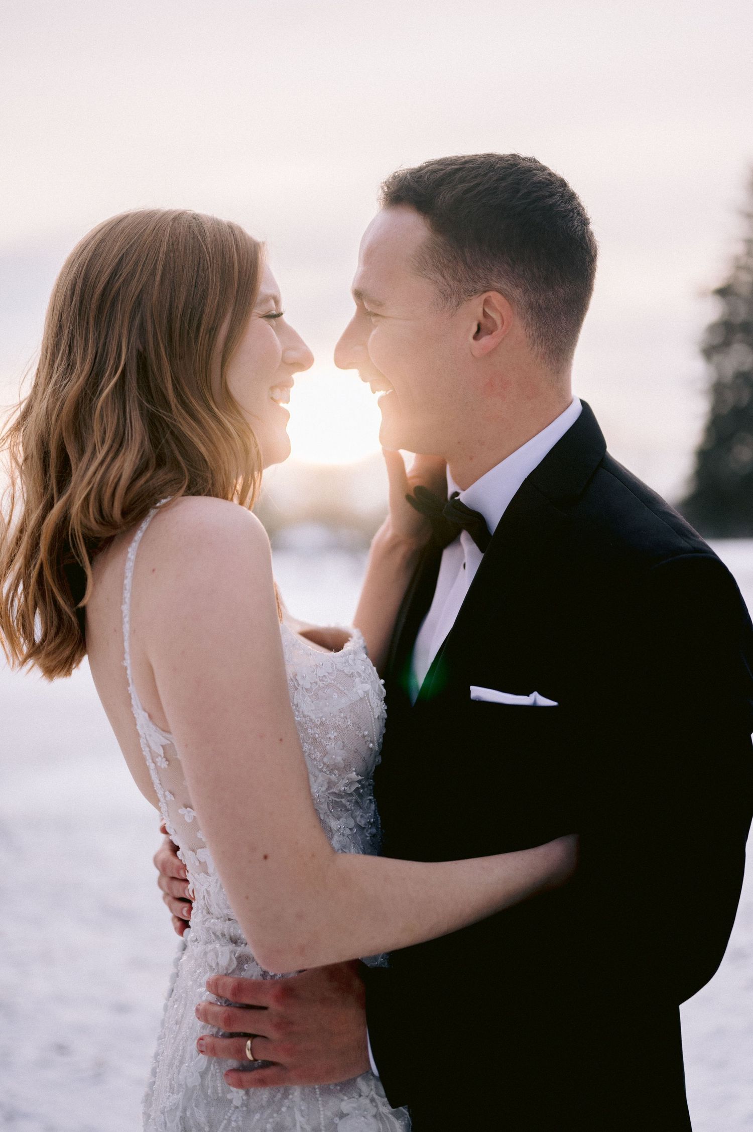 A romantic sunset moment between newlyweds sharing an intimate laugh.