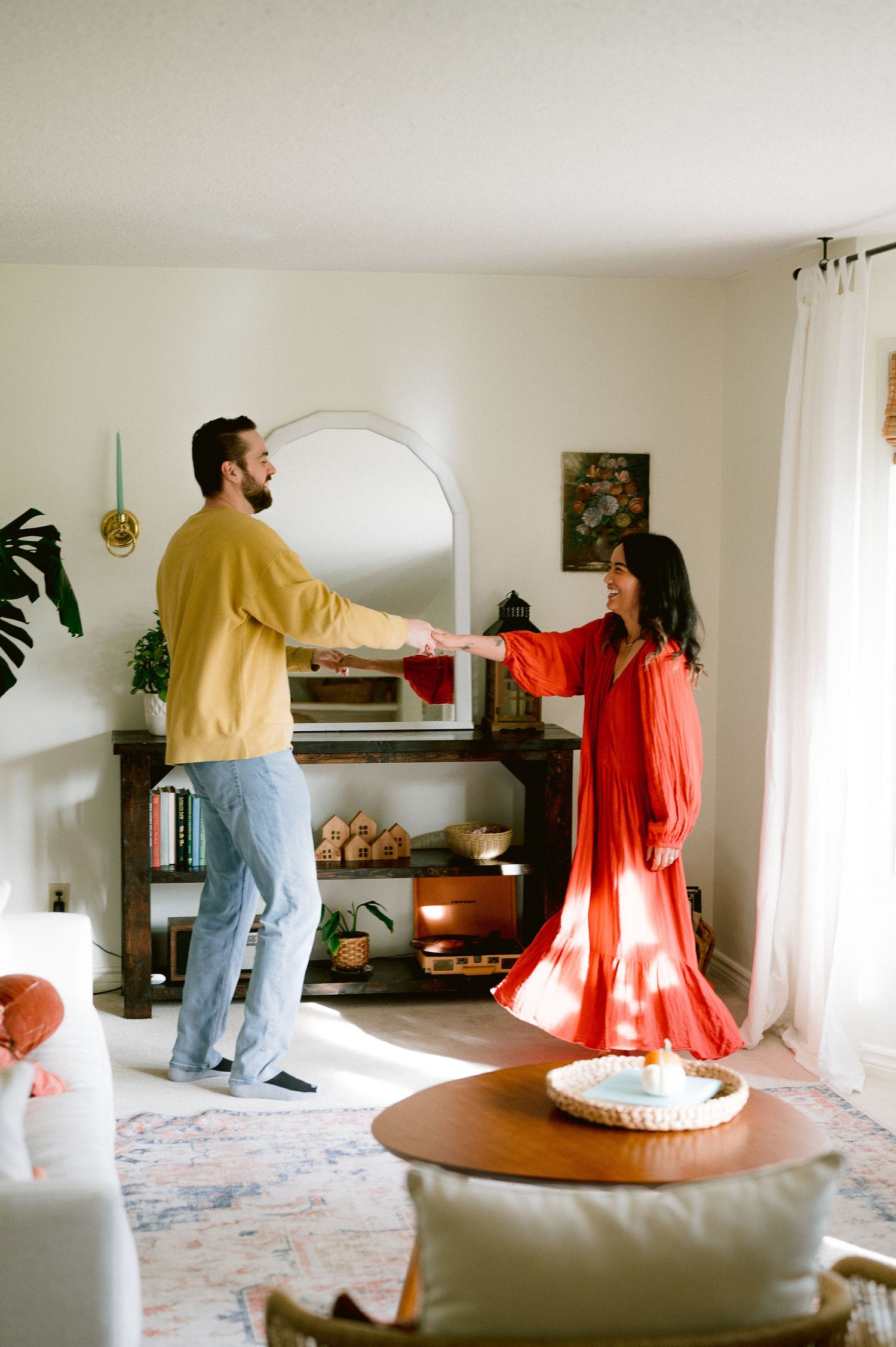 Couple dancing together in cozy living room with modern decor.
