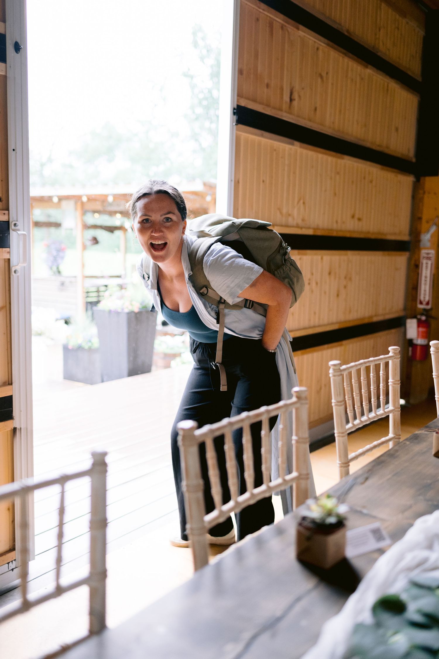 A sequence showing someone setting up chairs in a wooden venue space.