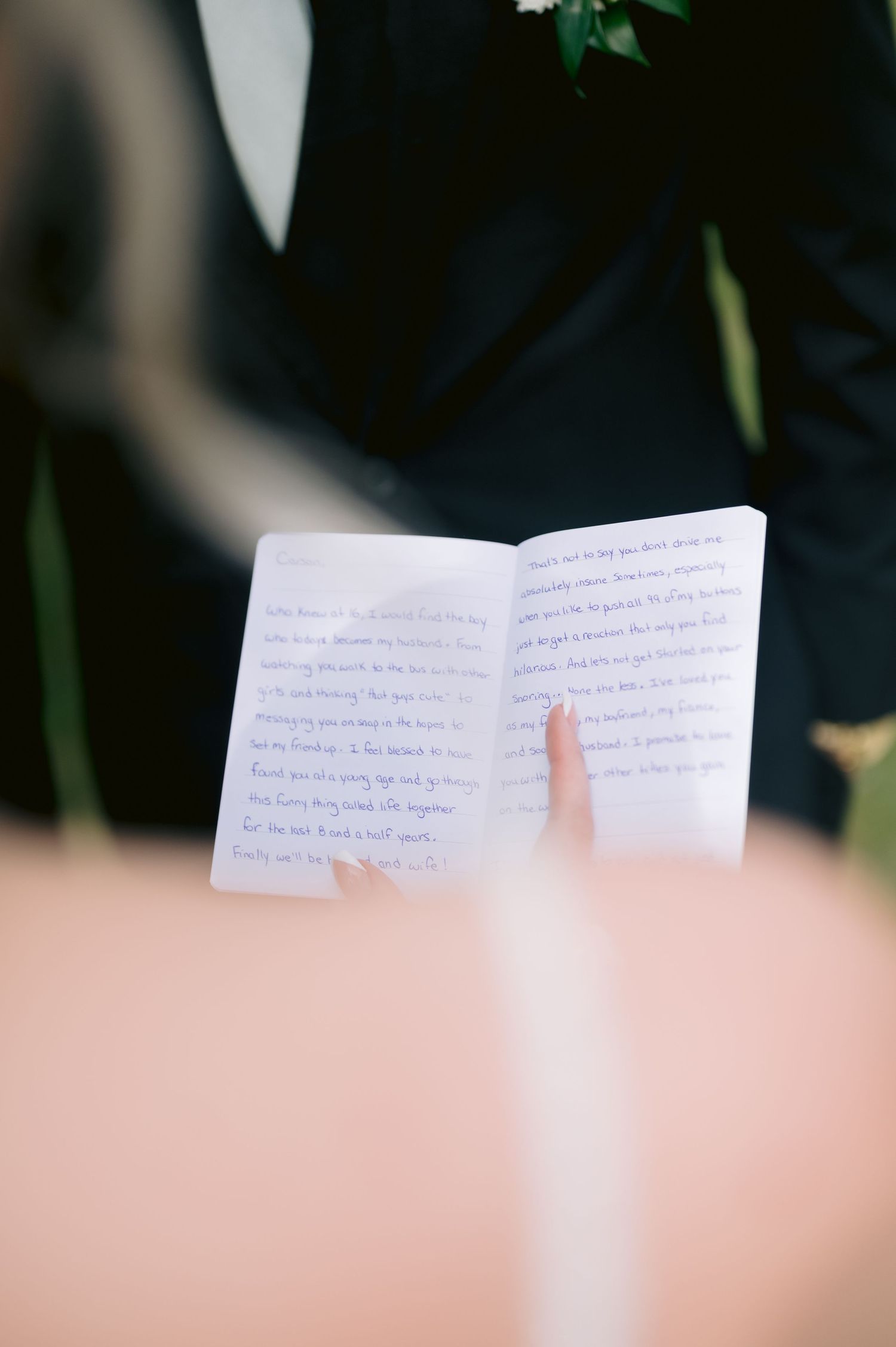 An open handwritten journal or vows book displayed during a wedding ceremony.