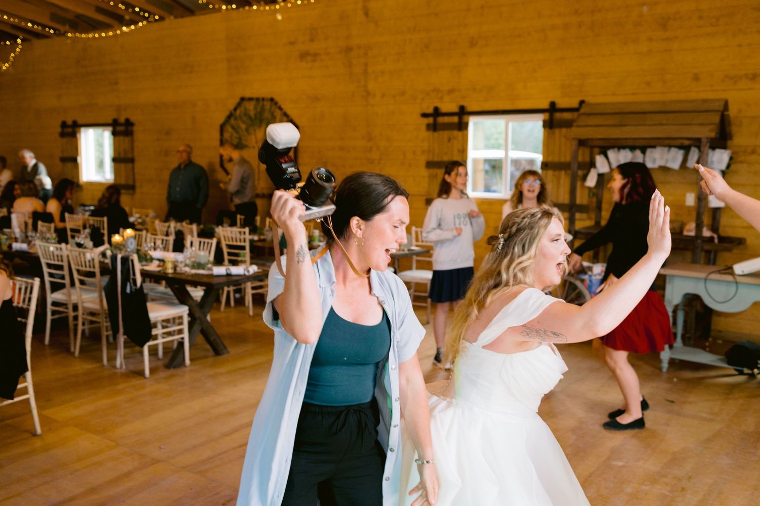 People celebrating in a rustic wooden hall decorated with string lights. Edmonton Alberta