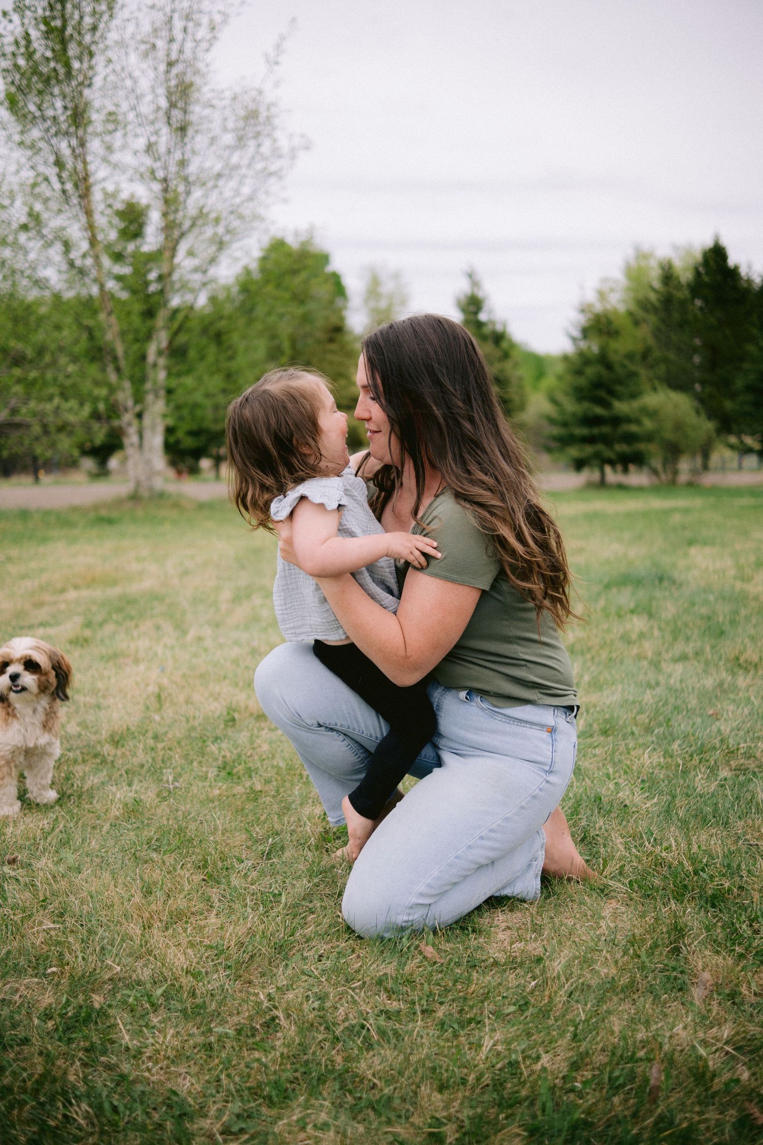 A playful sequence of photos showing two people embracing on grass with a small dog in the background.