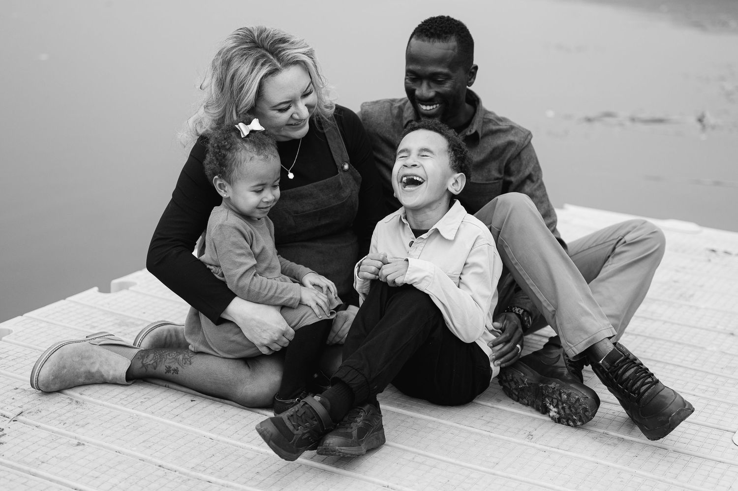Five sequential photos showing adults playing and laughing on the floor in a playful and joyful moment together.
