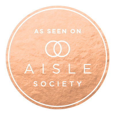 Rose gold metallic circular badge with 'As Seen on Aisle Society' text and interlocking rings logo design.
