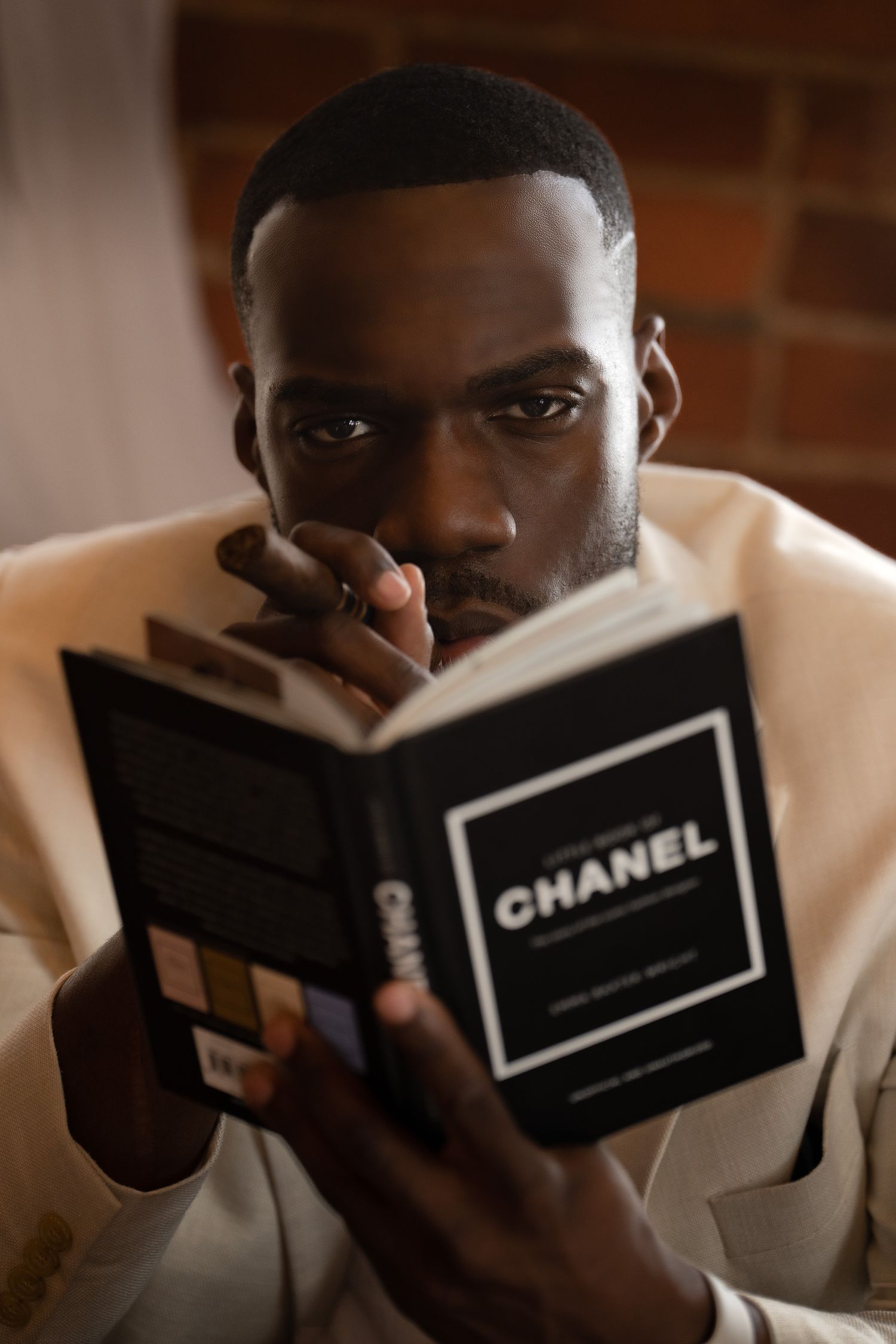Creative portrait series showing someone peeking behind a Chanel book.