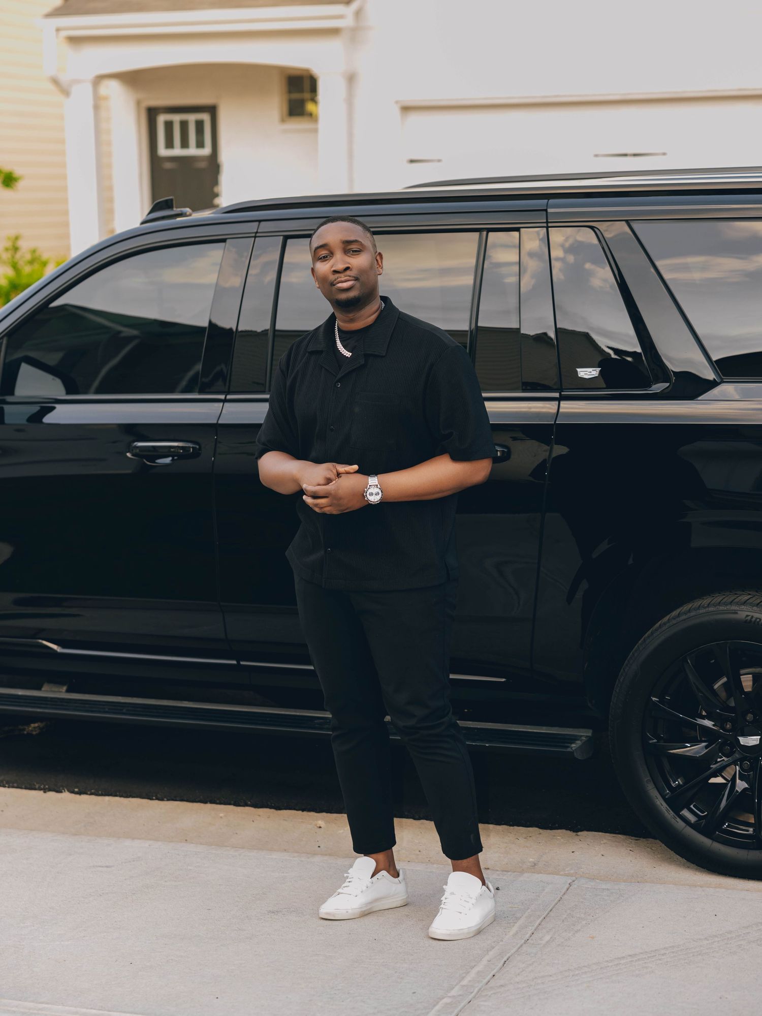 Casual street style photo shoot next to a black luxury SUV.
