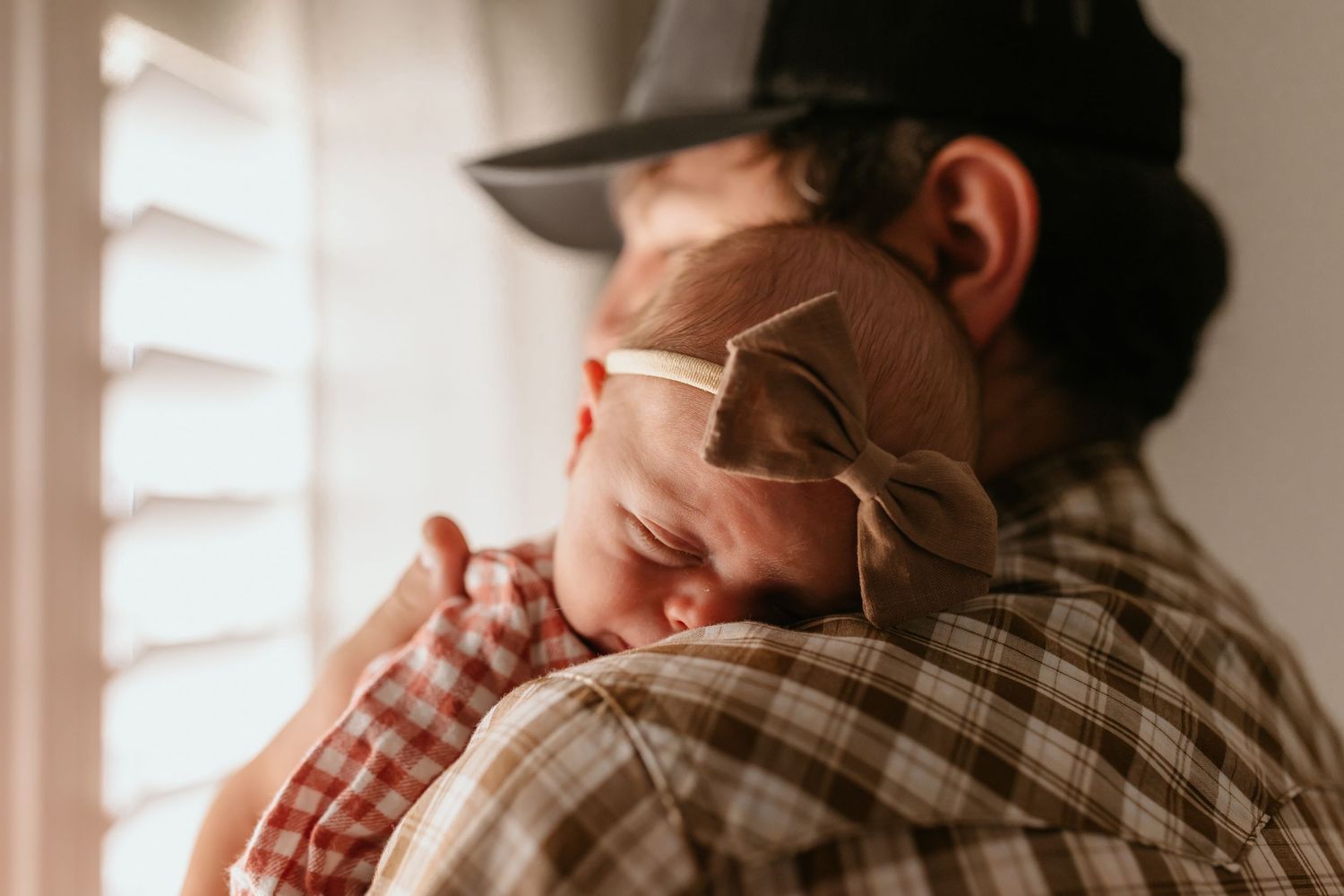 Intimate moment of comfort and connection as one person rests against another's shoulder.