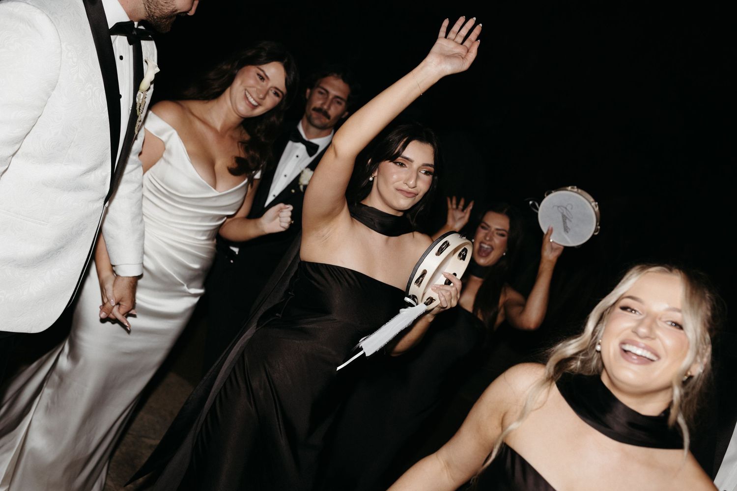 People dancing and enjoying themselves at a social gathering in a dark venue with blurred motion effects visible.