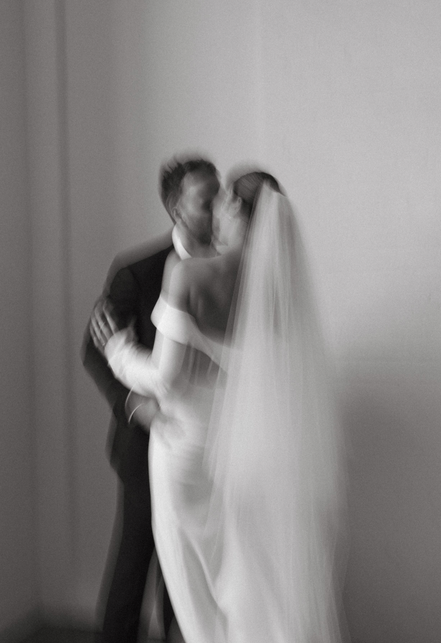 Ethereal black and white wedding portrait with soft motion blur effect.