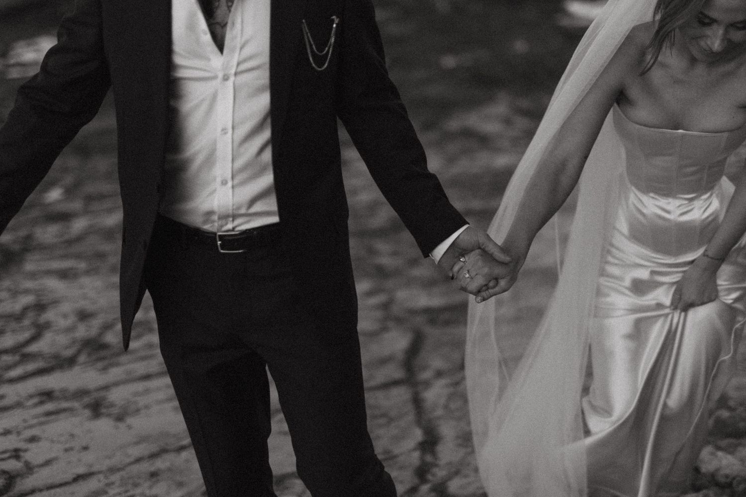 A romantic black and white wedding photograph shows a couple dancing, with the bride's dress swaying elegantly.