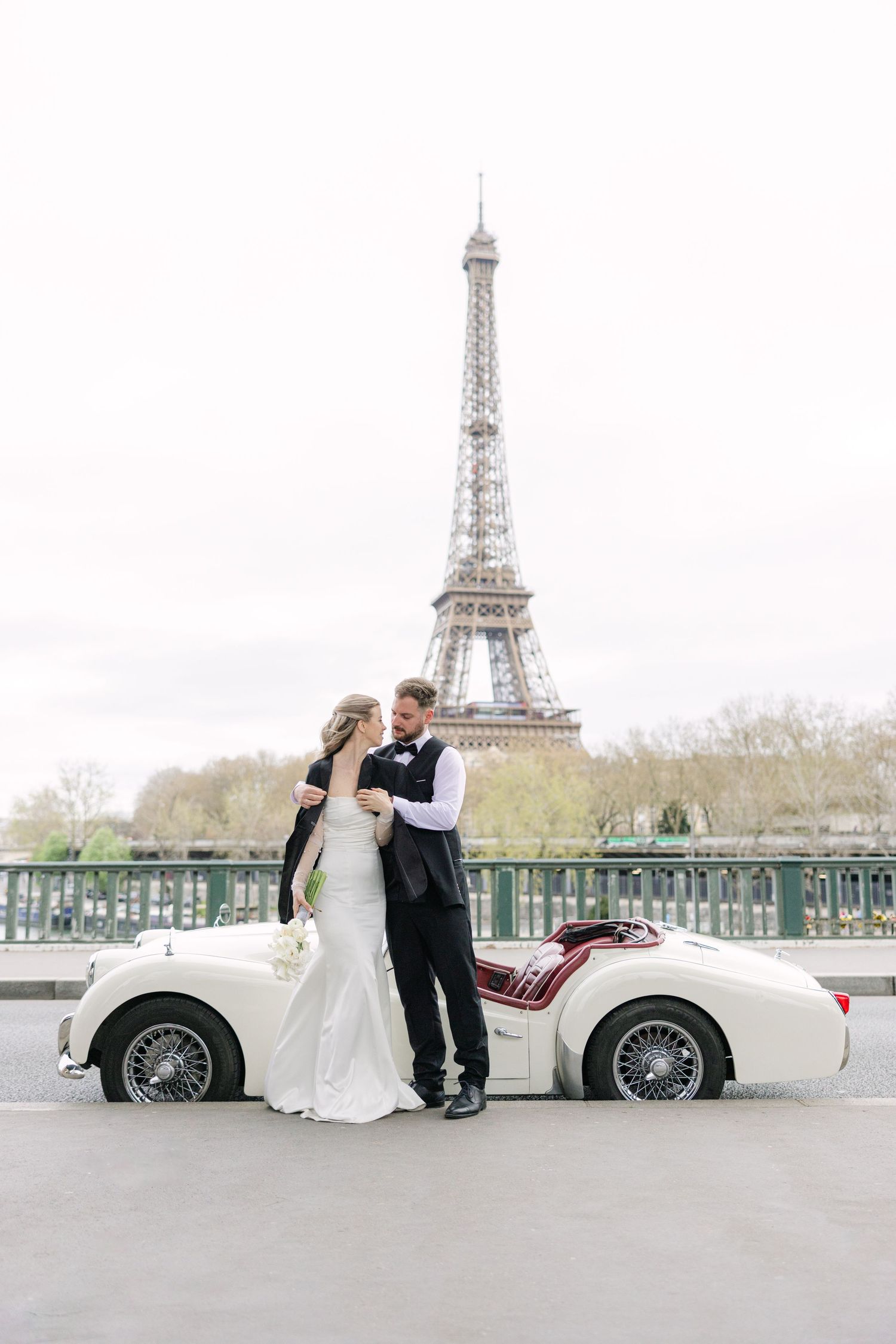 Bride and Groom Portrait with Eiffel Tower and a classic car in Paris by Miriam Caterina Wahl