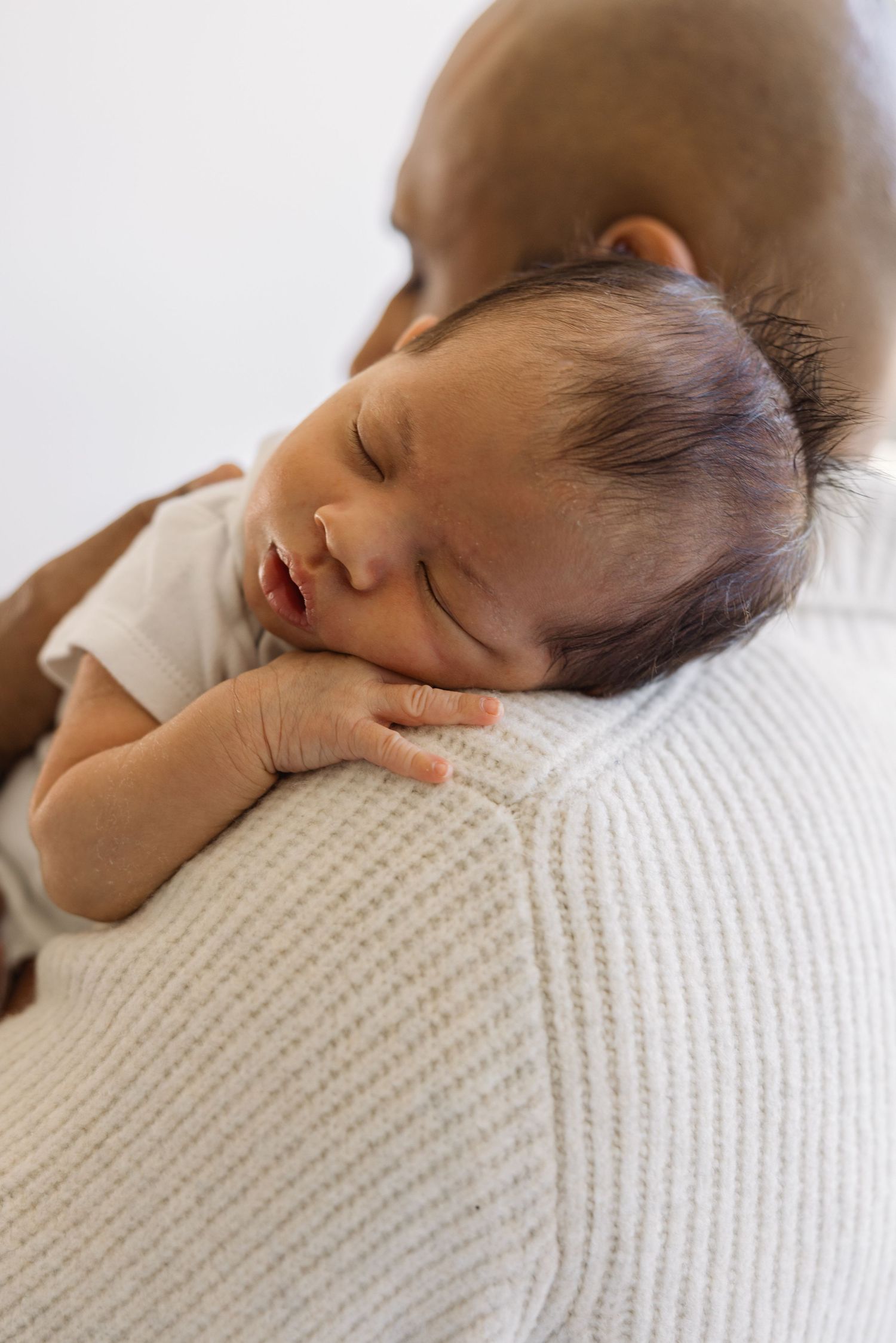 Baby peacefully resting on fathers shoulder