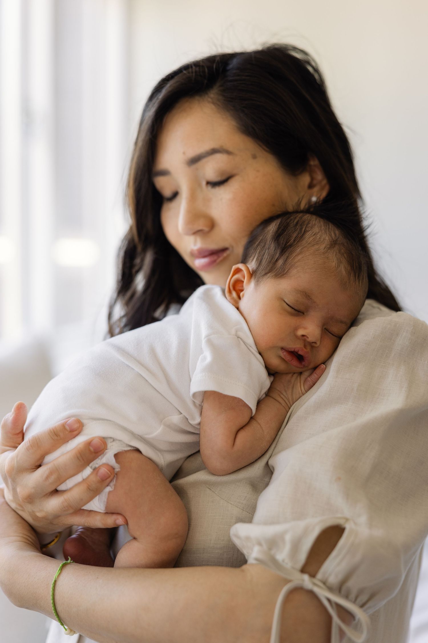 Newborn and mother cuddeling during newborn photo session