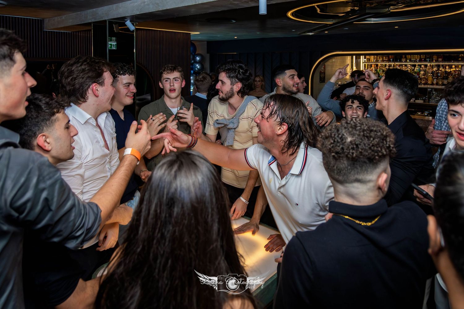 Excited crowd gathered in a circle celebrating at a nightclub event.