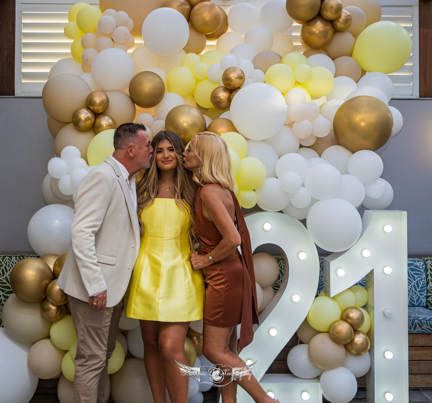 Balloon arch with gold, white and yellow balloons serves as party photo backdrop.