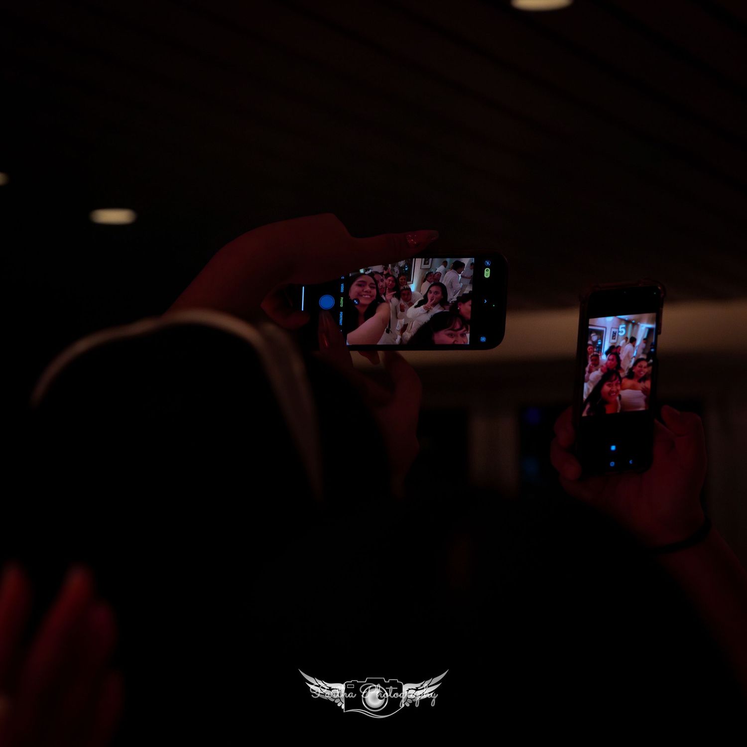 Camera phones record nighttime party moments with glowing screens in dark room.