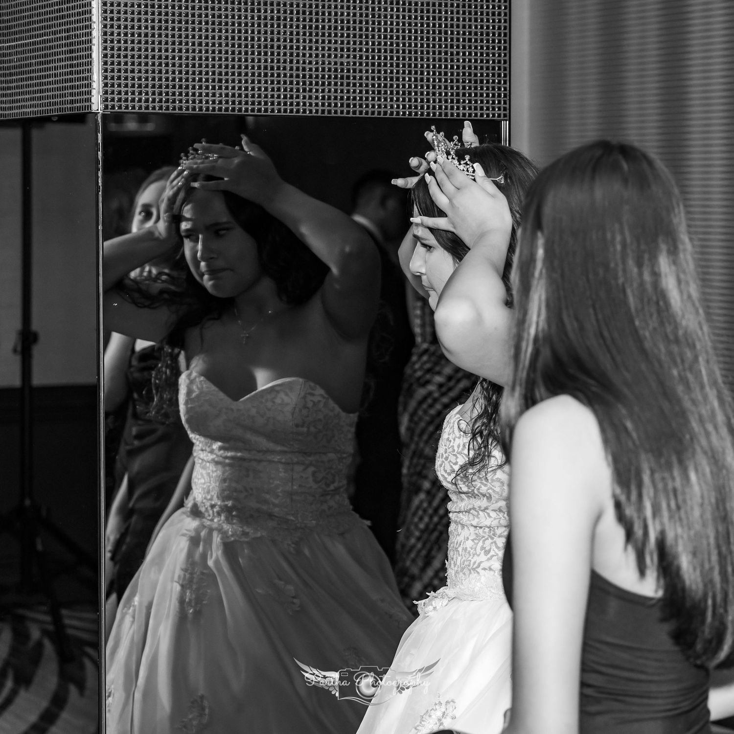 Two people in formal dresses getting ready for an event while adjusting their outfits in black and white.