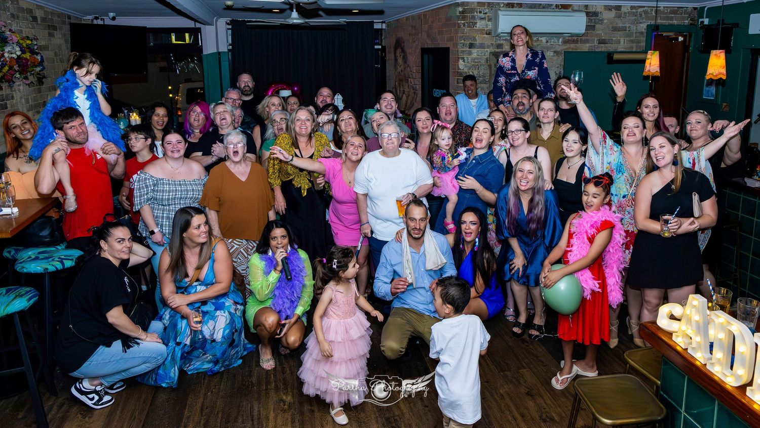 Large group of party guests gathered together for a celebration photo.