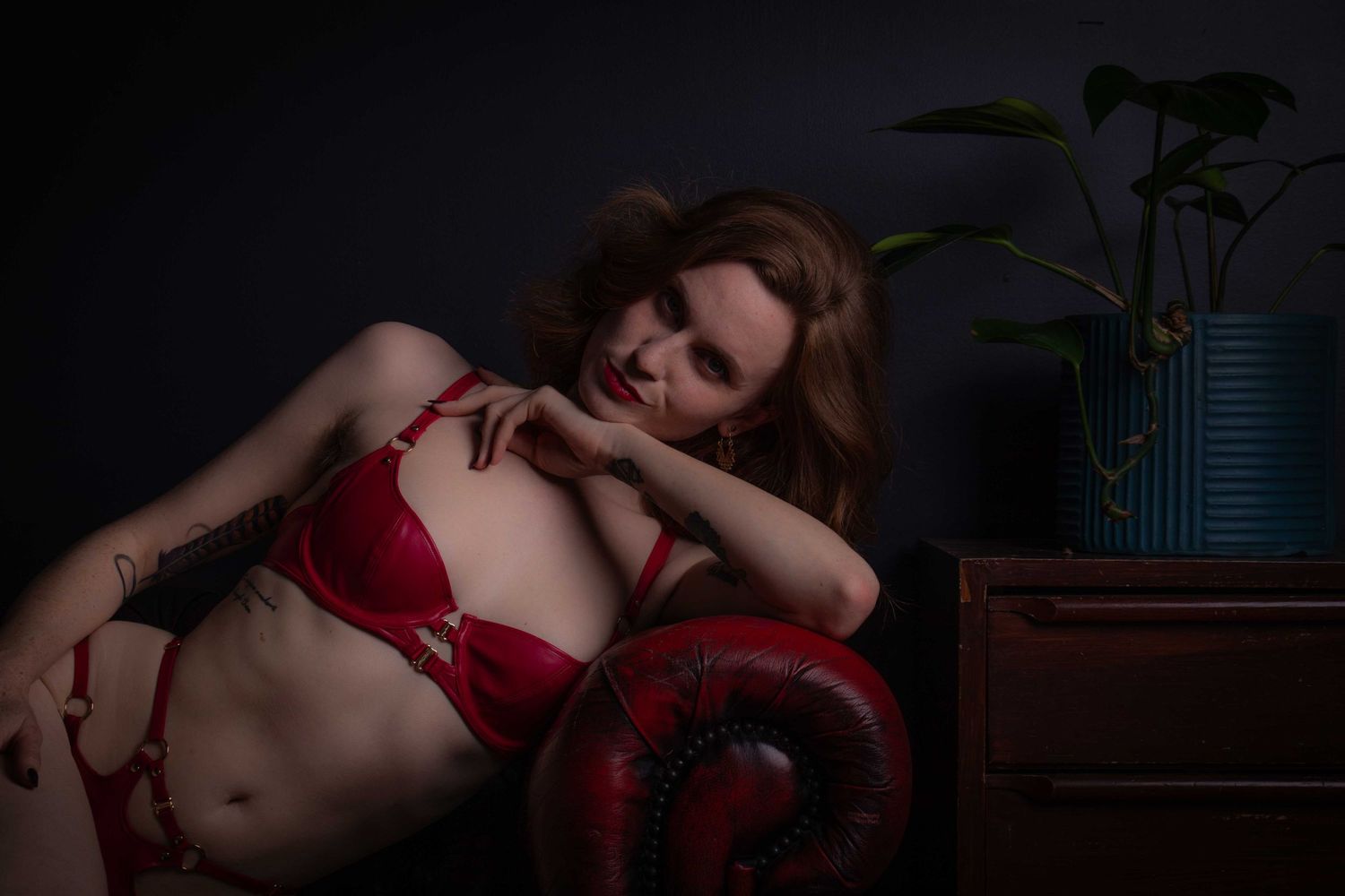 Intimate portrait session on leather furniture with dramatic lighting effects.