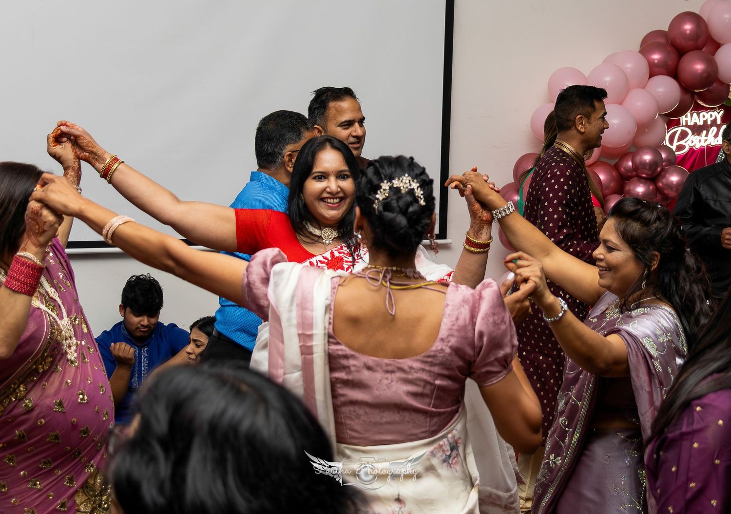 Group of party guests dancing together in a celebratory moment.