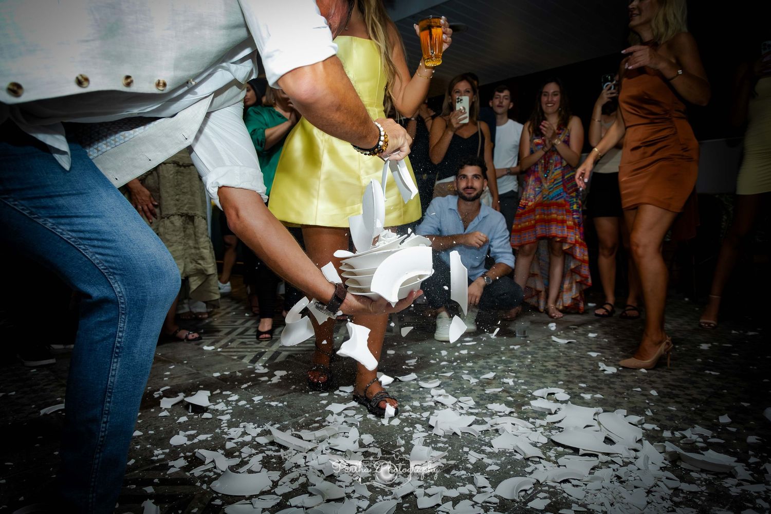 People dancing on confetti-covered floor at a nighttime celebration.